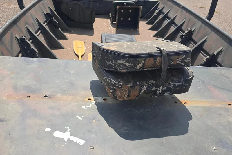 Slide: The Image of 1989 Polar Kraft 17 boat interior with camo cushions and wooden paddle. - 6