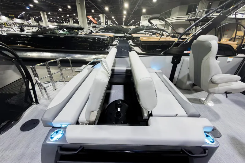 Slide: The Image of 2026 Godfrey Monaco 25' Tritoon with flip lounge seating at a boat show. - 24