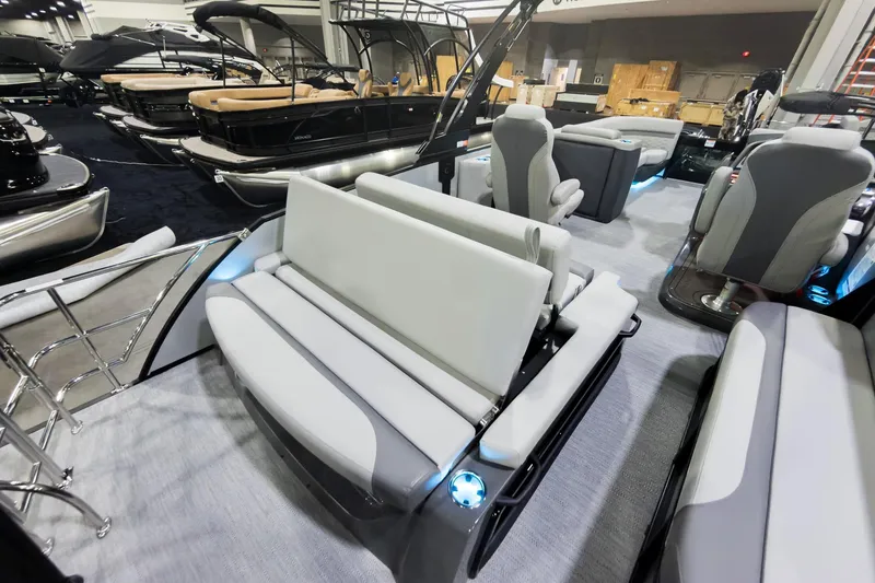 Slide: The Image of 2026 Godfrey Monaco 25' Tritoon with flip lounge seating, showcased indoors. - 25