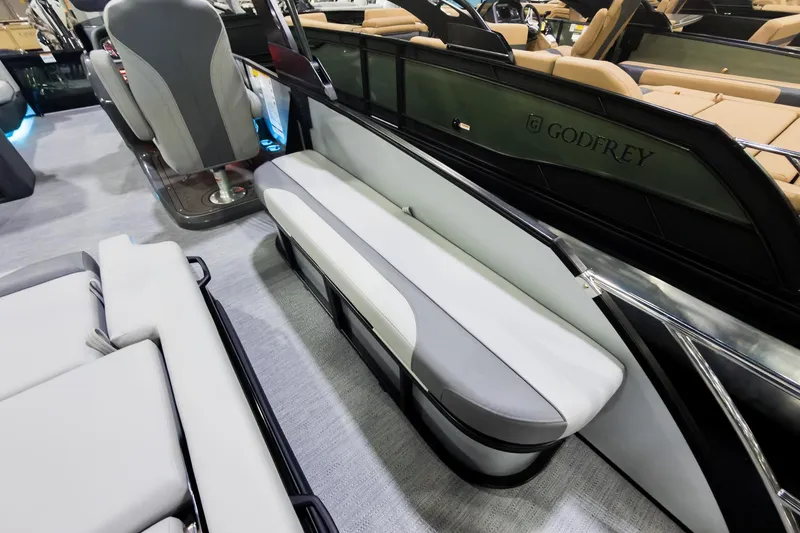 Slide: The Image of 2026 Godfrey Monaco 25' Tritoon interior with sleek seating and modern design. - 27