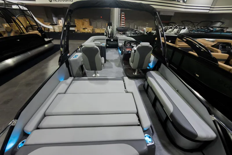 Slide: The Image of 2026 Godfrey Monaco 25' Tritoon with luxurious seating and modern design in showroom. - 30