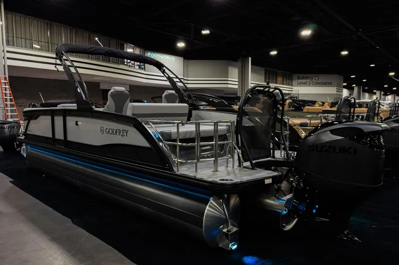 Slide: The Image of 2026 Godfrey Monaco 25' Tritoon boat with Suzuki engine displayed indoors. - 4
