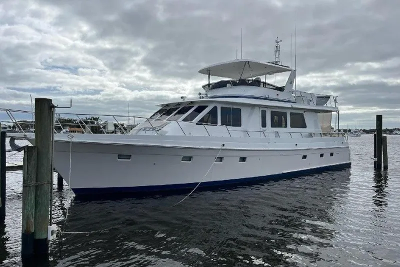 The Image of 2008 Offshore Yachts 62 Flushdeck, white luxury yacht docked on a cloudy day. - 0