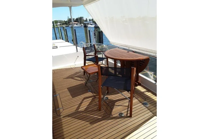 Slide: The Image of Cockpit Deck of 2008 Offshore Yachts 62 Flushdeck with wooden chairs and table. - 13