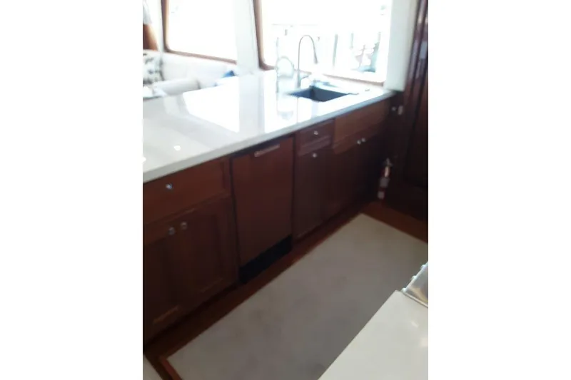 Slide: The Image of Luxurious kitchen area in 2008 Offshore Yachts 62 Flushdeck, featuring wooden cabinetry and modern sink. - 20