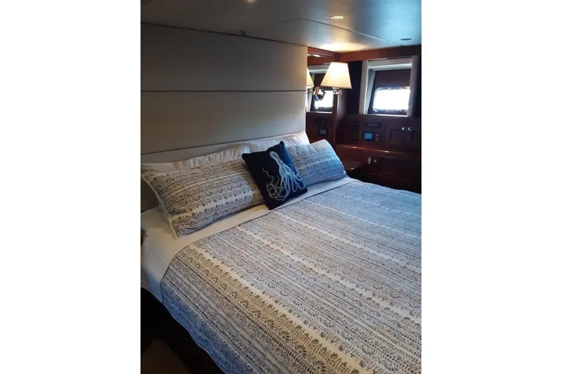 Slide: The Image of Master Stateroom with king bed and elegant bedding and additional new lighting. - 29