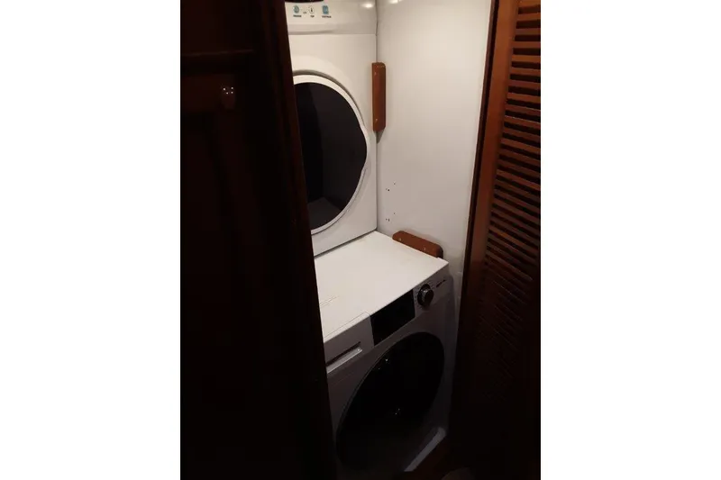 Slide: The Image of Laundry area with stacked washer and dryer in 2008 Offshore Yachts 62 Flushdeck. - 46