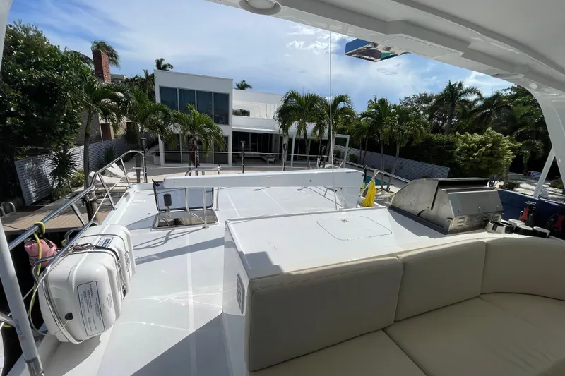 Slide: The Image of 2008 Offshore Yachts 62 Flushdeck with spacious deck, outdoor seating, and grill, docked near modern home. - 54