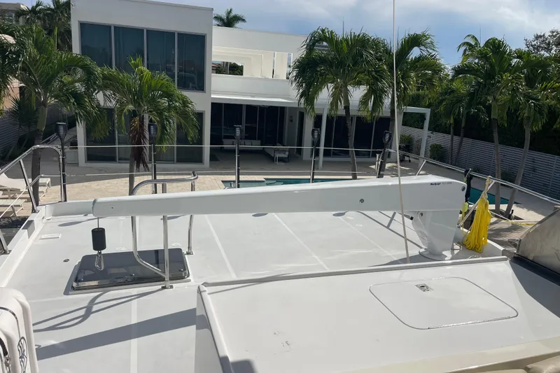 Slide: The Image of 2008 Offshore Yachts 62 Flushdeck, docked near modern house with palm trees. - 57