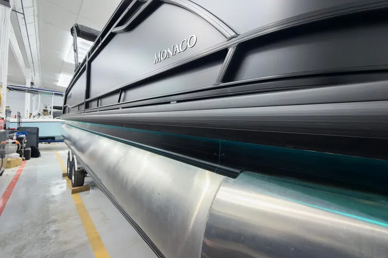 Slide: The Image of 2026 Godfrey Monaco 25' Tritoon in showroom, showcasing sleek design and modern features. - 10