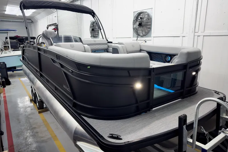 The Image of 2026 Godfrey Monaco 25' Tritoon with mid-table flip lounge in showroom. - 2