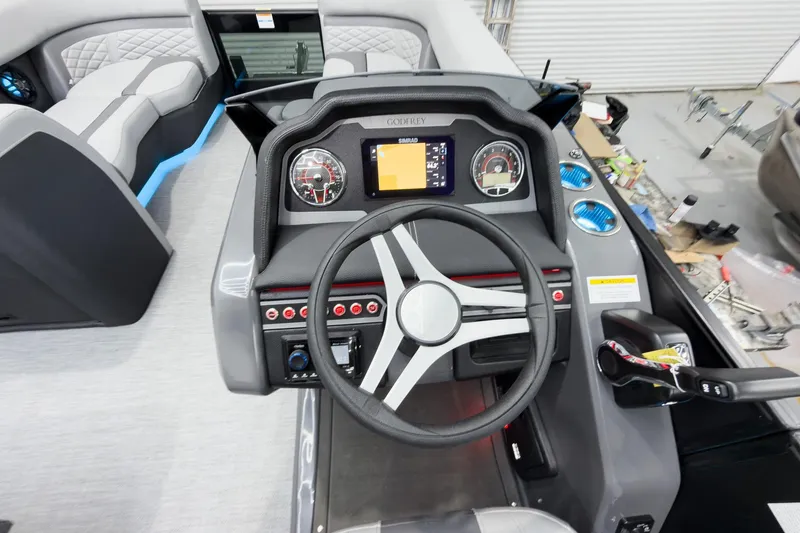 Slide: The Image of Cockpit view of 2026 Godfrey Monaco 25' Tritoon with modern dashboard and controls. - 22