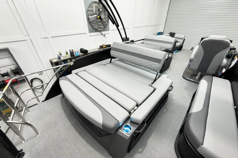 Slide: The Image of 2026 Godfrey Monaco 25' Tritoon interior with mid-table flip lounge seating. - 43