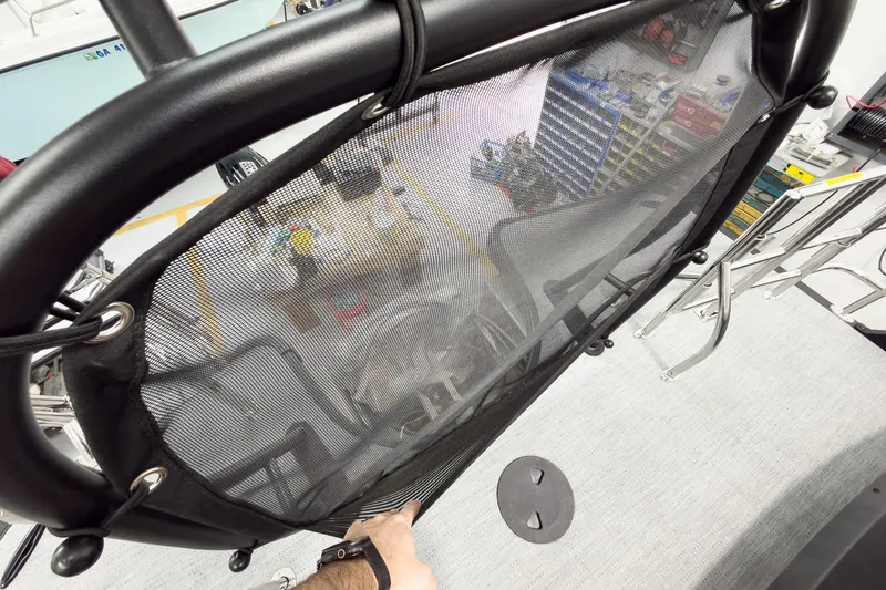 Slide: The Image of 2026 Godfrey Monaco 25' Tritoon with mid-table flip lounge, featuring a mesh safety barrier. - 53