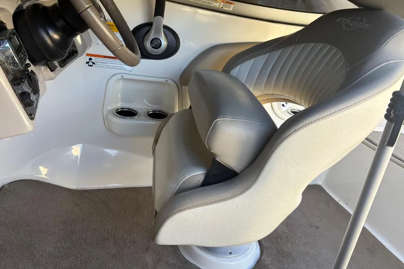Slide: The Image of Interior of a 2014 Stingray 198 LX boat featuring a steering wheel and captain's chair. - 13