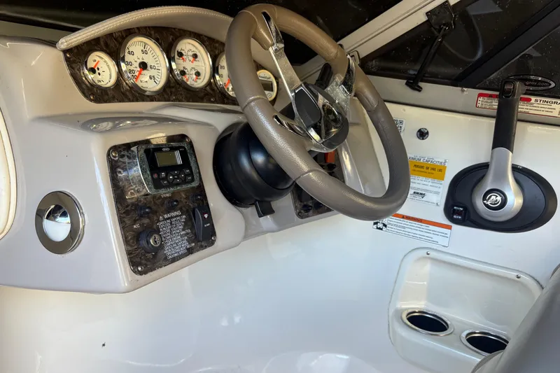 Slide: The Image of 2014 Stingray 198 LX boat dashboard with steering wheel and control panel. - 14