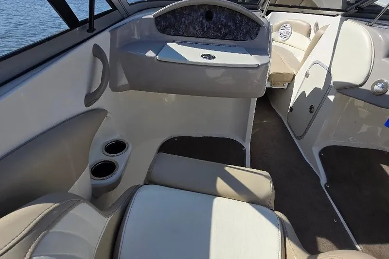 Slide: The Image of Interior of a 2014 Stingray 198 LX boat, featuring beige seating and cup holders. - 16
