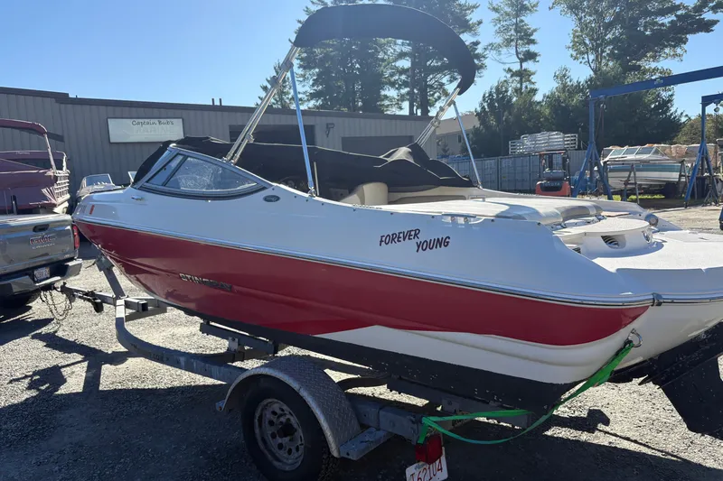 Slide: The Image of 2014 Stingray 198 LX boat named "Forever Young" on trailer in outdoor setting. - 2