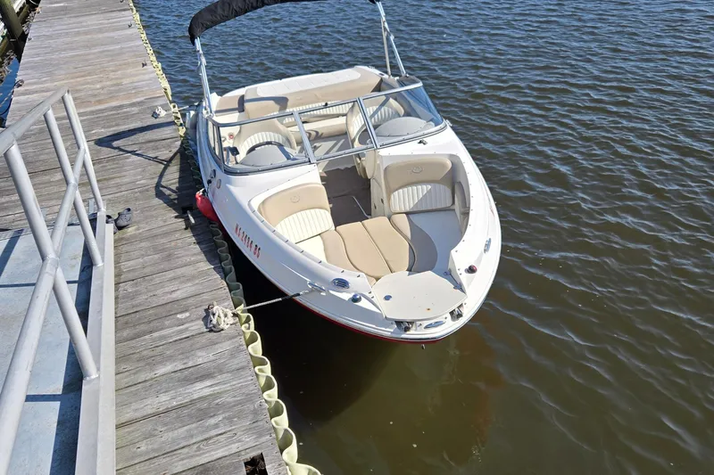 Slide: The Image of 2014 Stingray 198 LX boat docked on calm water beside a wooden pier. - 4