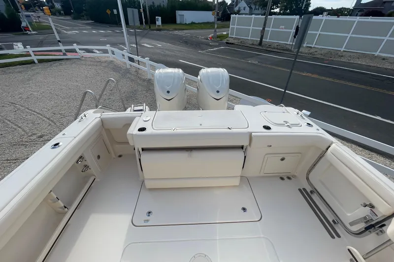 Slide: The Image of 2026 Grady-White Canyon 326 boat with dual engines, docked near a road. - 21