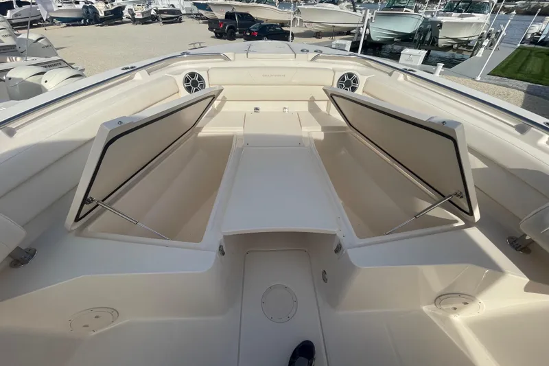 Slide: The Image of 2026 Grady-White Canyon 326 boat with open storage compartments, docked at marina. - 3