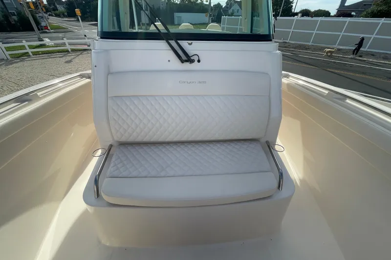 Slide: The Image of 2026 Grady-White Canyon 326 boat seat with quilted white upholstery. - 6