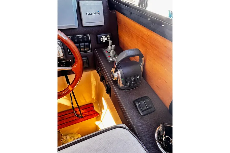 Slide: The Image of 2014 Cutwater C-28 helm with Garmin navigation, wooden steering wheel, and control panel. - 17