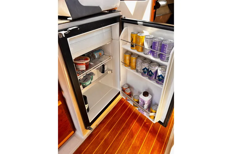 Slide: The Image of Open fridge in 2014 Cutwater C-28 boat, stocked with cans and food items. - 27