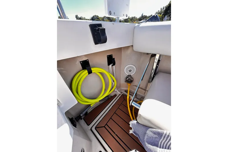 Slide: The Image of 2014 Cutwater C-28 boat interior with coiled yellow hose and teak flooring. - 39