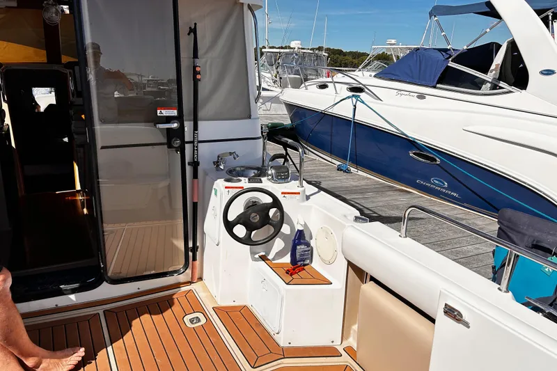 Slide: The Image of 2014 Cutwater C-28 boat interior with helm, docked beside another vessel. - 7