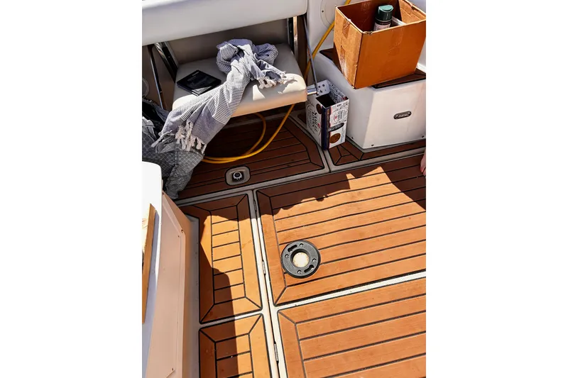 Slide: The Image of 2014 Cutwater C-28 boat deck with wooden flooring, seat, and storage items. - 8