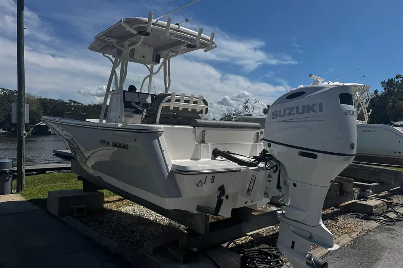 The Image of 2023 Sea Born FX22 Bay boat with Suzuki outboard motor docked by the water. - 1