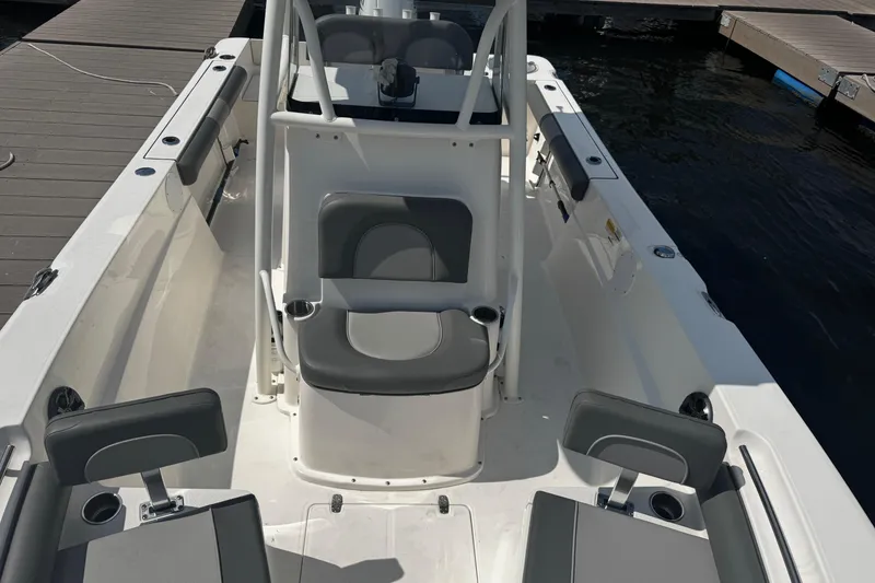 Slide: The Image of 2023 Sea Born FX22 Bay boat interior with seating and console, docked by the water. - 4