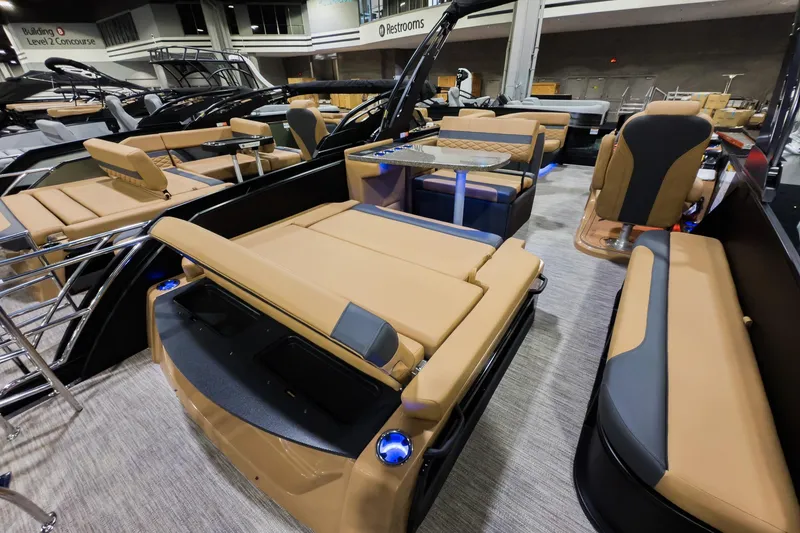 Slide: The Image of 2026 Godfrey Monaco 255 boat with luxurious seating and modern design at an indoor showroom. - 24