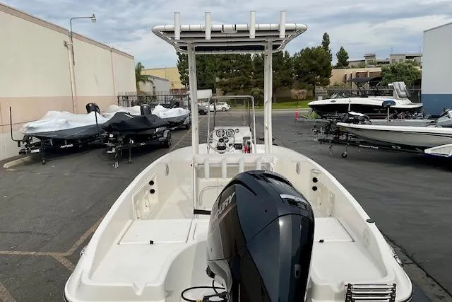 Slide: The Image of 2025 Bayliner Trophy T18 boat in a marina, featuring a sleek design and powerful outboard motor. - 18