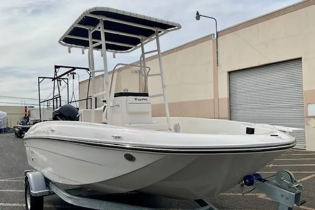 Slide: The Image of 2025 Bayliner Trophy T18 boat on trailer, parked outdoors near a building. - 3