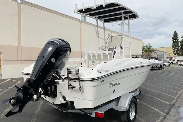 Slide: The Image of 2025 Bayliner Trophy T18 boat on trailer, featuring outboard motor and T-top canopy. - 5