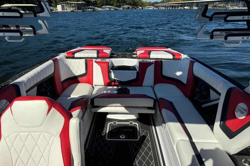 Slide: The Image of 2022 Tigé 25ZX boat interior with red and white seating on a lake. - 11