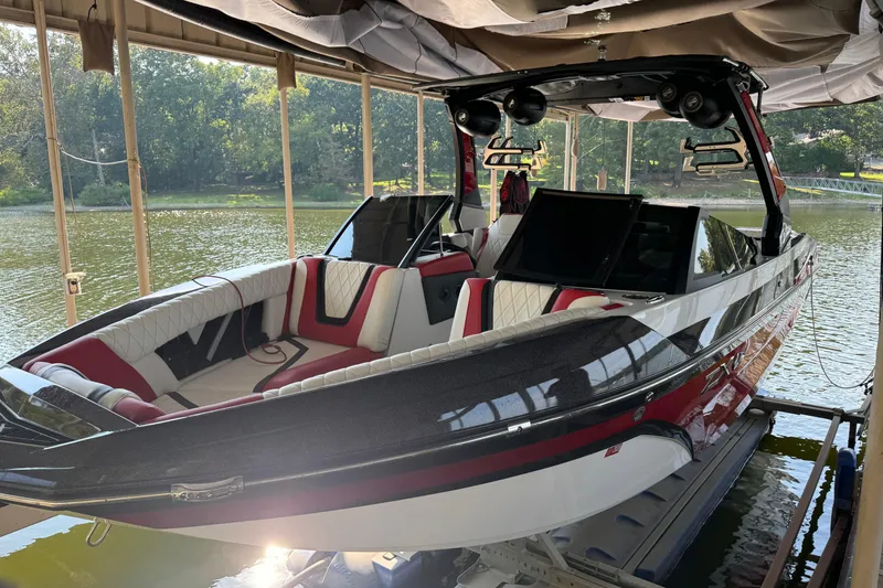 Slide: The Image of 2022 Tigé 25ZX boat interior with red and white seating on water. - 2