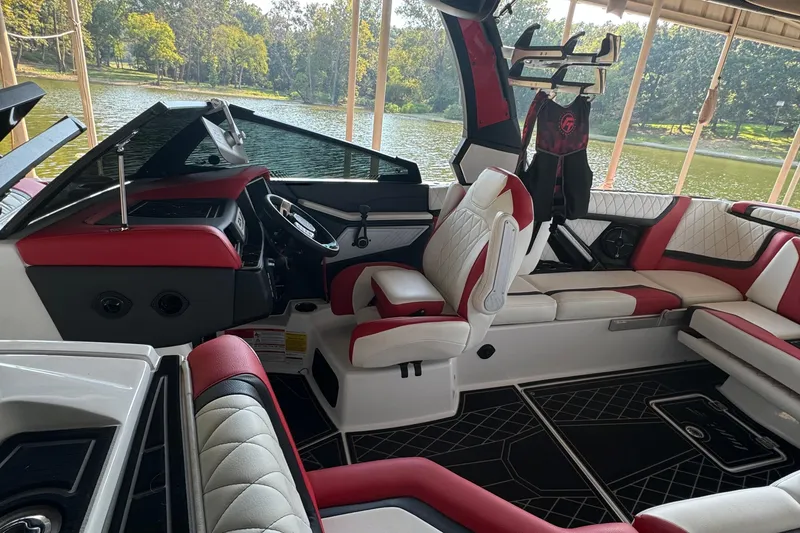 Slide: The Image of 2022 Tigé 25ZX boat interior with red and white seating, modern dashboard, and steering wheel. - 3