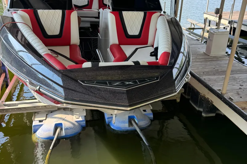 Slide: The Image of 2022 Tigé 25ZX boat interior with red, white, and black seating, featuring diamond stitching. - 7