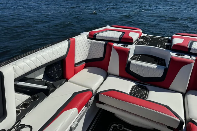 Slide: The Image of 2022 Tigé 25ZX boat interior with red and white seating on a lake. - 8