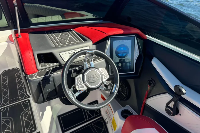 Slide: The Image of 2022 Tigé 25ZX boat dashboard with touchscreen and steering wheel, featuring red and black accents. - 9