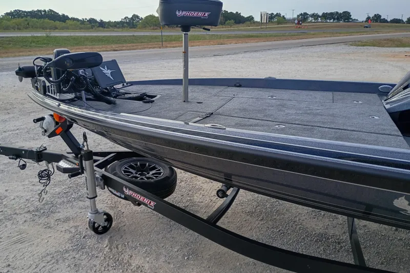 Slide: The Image of 2026 Phoenix 921 ELITEX boat on trailer, parked on gravel near highway. - 11