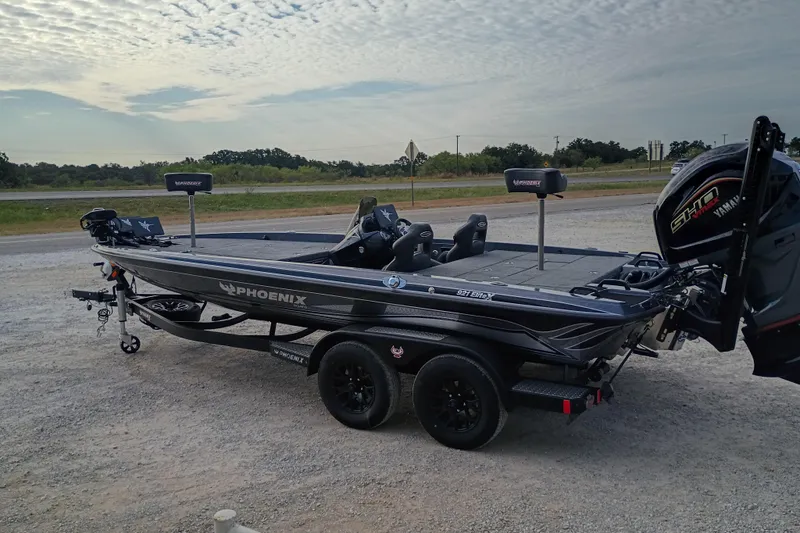 Slide: The Image of 2026 Phoenix 921 ELITEX fishing boat on trailer, parked outdoors under cloudy sky. - 2