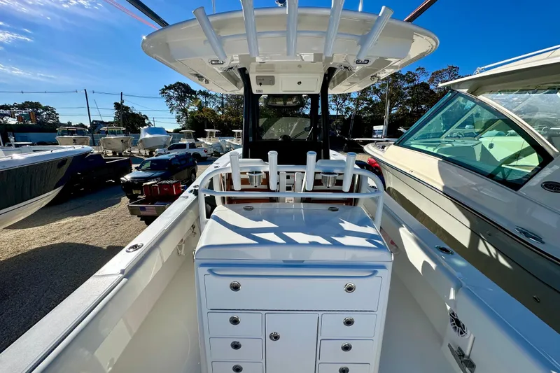 Slide: The Image of 2026 Regulator 31 boat interior with rod holders and storage, parked in a marina. - 14