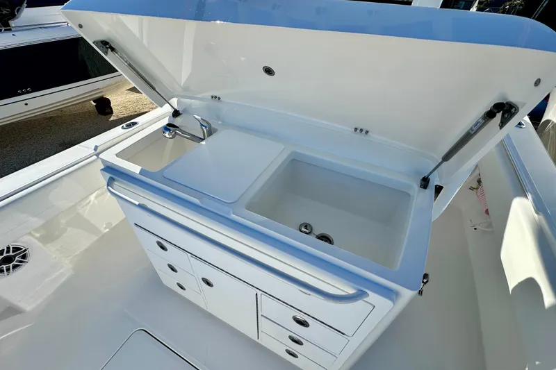 Slide: The Image of 2026 Regulator 31 boat sink and storage area with open lid. - 15