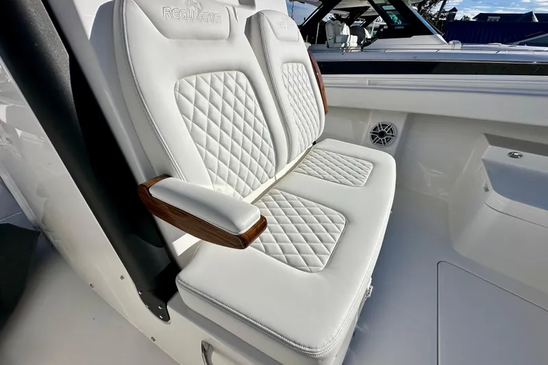 Slide: The Image of Luxurious seating on 2026 Regulator 31 boat with quilted white upholstery and wooden armrests. - 22