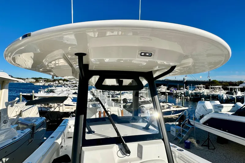 Slide: The Image of 2026 Regulator 31 boat with T-top, docked in a marina under clear blue sky. - 23