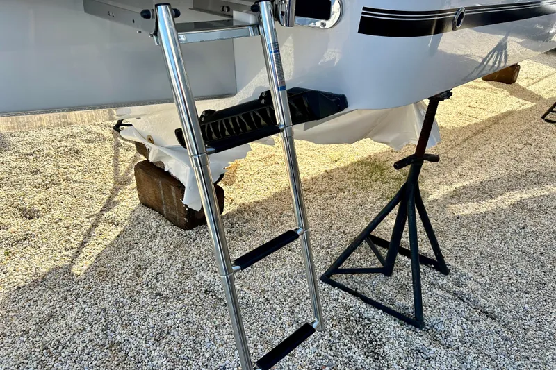 Slide: The Image of Stainless steel ladder on 2026 Regulator 31 boat, resting on gravel. - 24